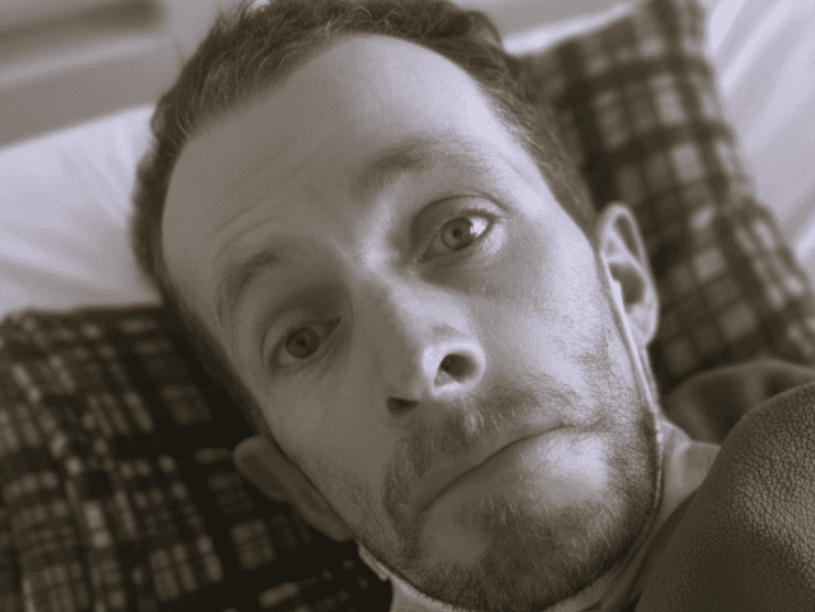 Herencia del alma: primer plano en blanco y negro de un hombre de mirada noble y profunda, con ojos claros que reflejan serenidad y una leve sonrisa; la iluminación suave resalta la paz de su expresión, simbolizando la herencia espiritual y el amor inquebrantable que trasciende la pérdida física.